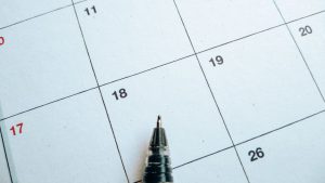 a calendar with a pen on top