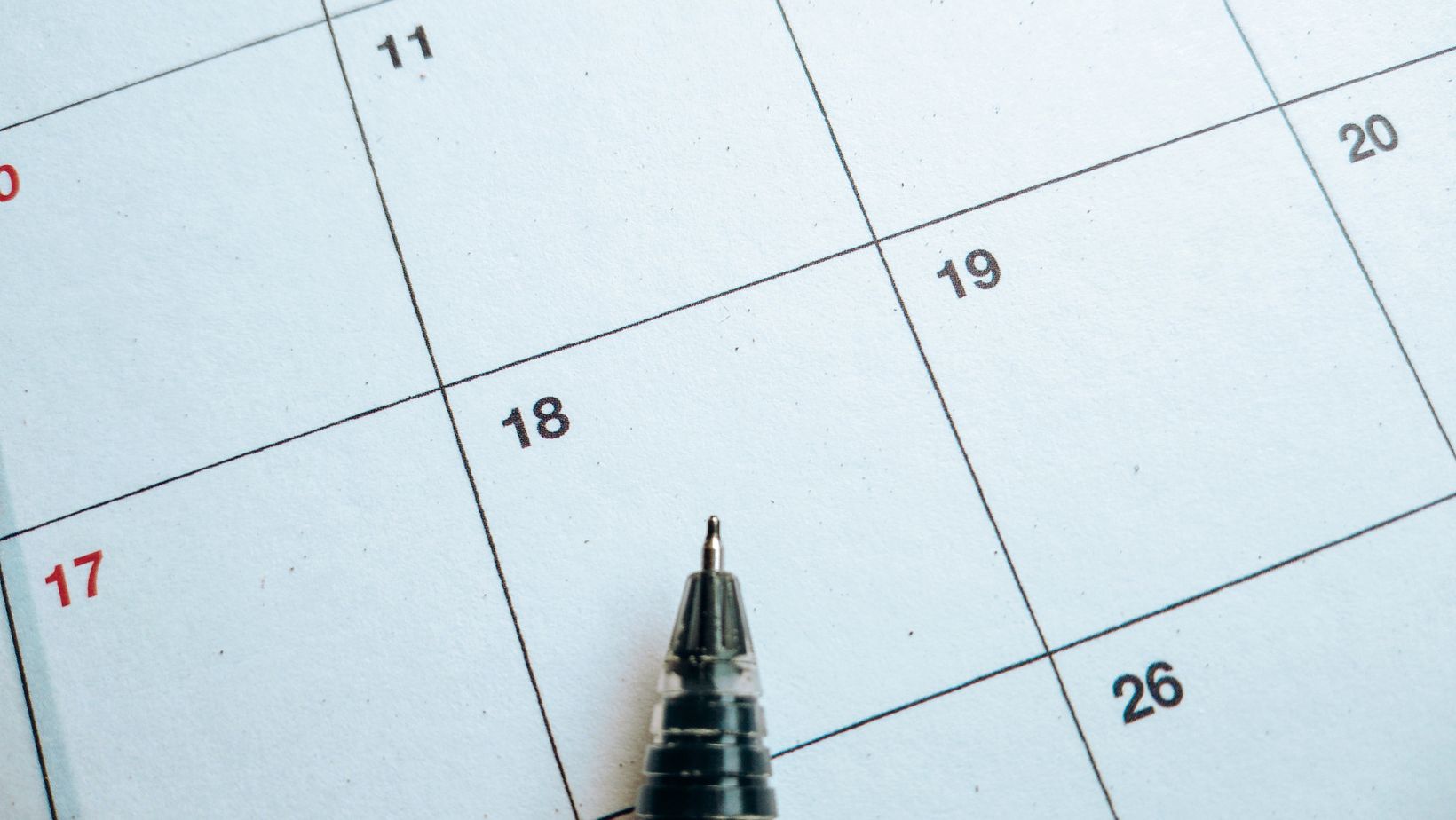 a calendar with a pen on top
