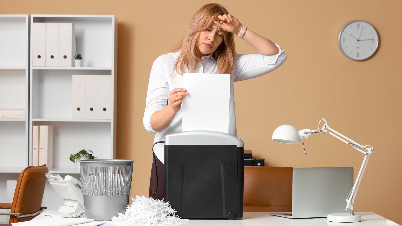 office worker using a office shredding thinking about if a professional shredding service is a better option